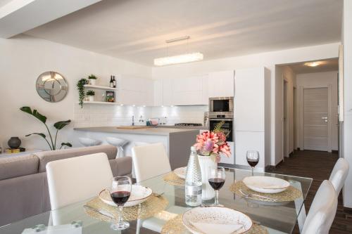 a dining room and kitchen with a glass table and chairs at Electra Residence - Luxury Central Beachview Apartment in Marsalforn