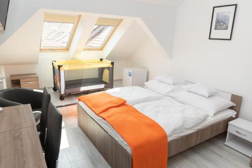 sypialnia z dużym łóżkiem i pomarańczowym kocem w obiekcie Keresztúri Vendégház w mieście Bodrogkeresztúr