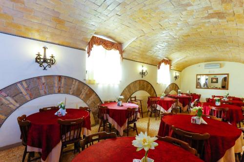 a restaurant with red tables and chairs and a ceiling at Hotel Tempio Di Pallade in Rome