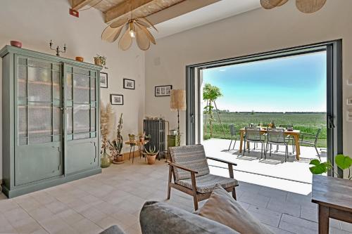 ボーケールにあるMas des Prépresses - la Maison des vendangeursのリビングルーム(ソファ付)、大きなスライド式ガラスドア