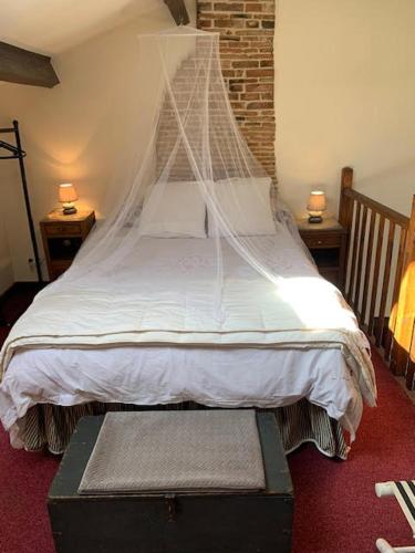 une chambre avec un lit avec moustiquaire dans l'établissement Red Gate Cottage, à Saulgond