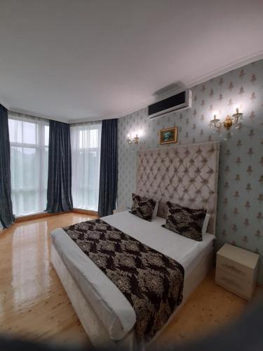 1 dormitorio con 1 cama en una habitación con ventanas en Raffles Villa with pool, en Gabala
