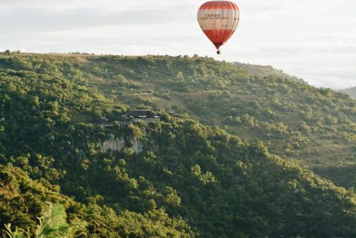 a hot air balloon flying over a mountain at Esiweni Luxury Safari Lodge in Nambiti Private Game Reserve