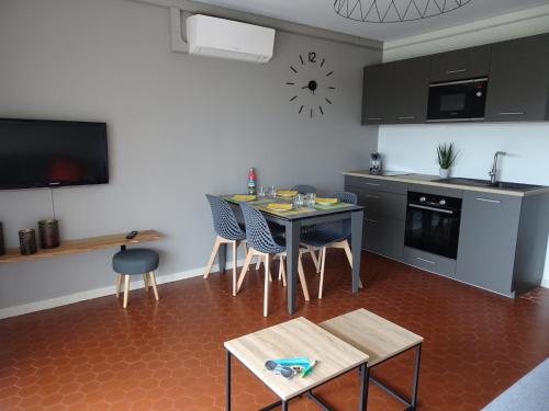 a kitchen with a table and chairs in a room at T3 150 m de la plage, climatisation, piscine et parking privatif - Le Lavandou in Le Lavandou