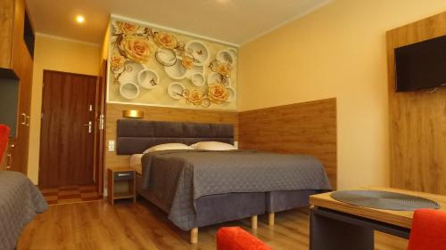 a hotel room with a bed and a wall with plates at Gościniec Pod Polną Różą in Międzyzdroje