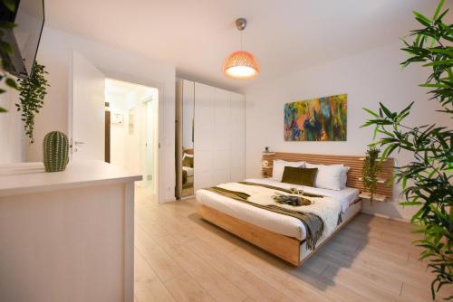 Un dormitorio con una cama y una planta en maceta. en The Comfy Spot - 1 BR-Apartment & Parking Included in North Business Area, en Bucarest