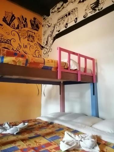 a bunk bed in a room with a mural at Rossco Hostel & Hotel in San Cristóbal de Las Casas