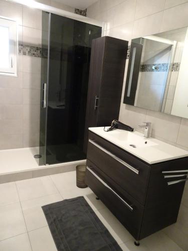 une salle de bain avec un lavabo et une douche dans l'établissement T3 150 m de la plage, climatisation, piscine et parking privatif - Le Lavandou, au Lavandou