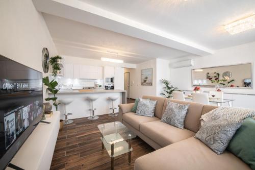 uma sala de estar com um sofá e uma cozinha em Electra Residence - Luxury Central Beachview Apartment em Marsalforn