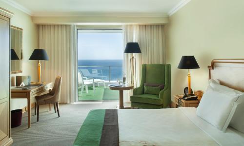 Habitación de hotel con cama, escritorio y balcón. en Hotel Cascais Miragem Health & Spa, en Cascais