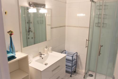 une salle de bain blanche avec un lavabo et une douche dans l'établissement CORTADERIA B002, à Saint-Cyprien
