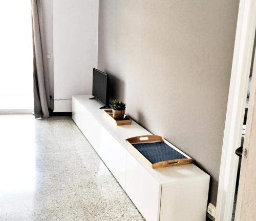 a living room with a tv on a white cabinet at Apartament a la Costa Brava l'Estartit - MyAnna in L'Estartit