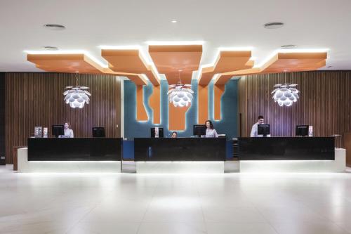 a lobby with people working at a reception desk at Hotel Riu Costa del Sol - All Inclusive in Torremolinos