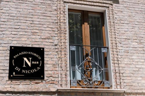 una ventana con una señal en el lateral de un edificio de ladrillo en B&B Palazzo Storico Di Nicola, en Pescara