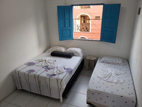 a small bedroom with a bed and a window at Pousada Novo Horizonte in Barreirinhas