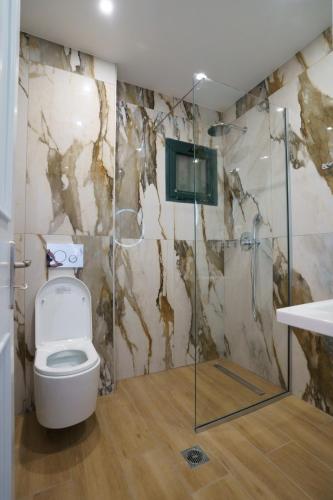 a bathroom with a toilet and a shower at Eleni Studios Parga in Parga
