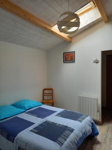 a bedroom with a blue bed and a ceiling at La Teranga proche La Rochelle in Nuaillé-dʼAunis