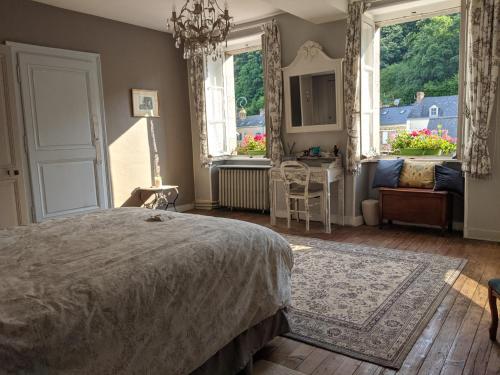 une chambre avec un lit, une table et des fenêtres dans l'établissement Sweeting's B & B Chailland, à Chailland