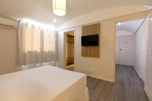 um quarto com uma cama e uma televisão na parede em Fênix Hotel Moema em São Paulo