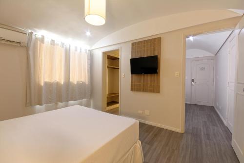 a bedroom with a bed and a tv on a wall at Fênix Hotel Moema in São Paulo