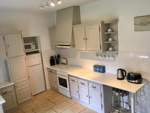 a kitchen with white cabinets and a counter top at Le Logis de Limalonges in Limalonges