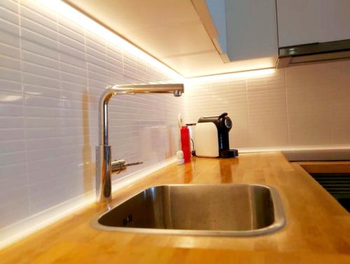 a kitchen sink with a faucet on a counter at Casa do Arco by HnM in Tavira