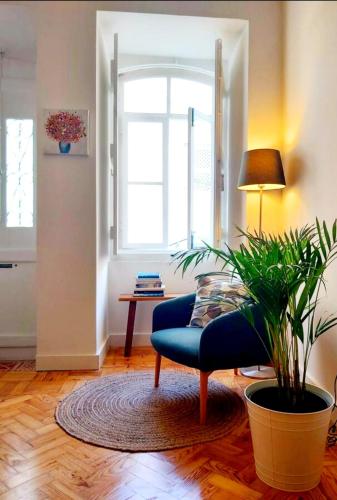 a living room with a blue couch and a plant at Casa do Arco by HnM in Tavira