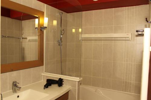 uma casa de banho com um chuveiro, um lavatório e um espelho. em Résidence Christiana 307 Clés Blanches Courchevel em Courchevel