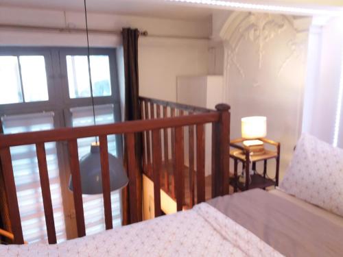 a bedroom with a bed and a balcony with a window at Studio la Nuit au Coeur de ville in Limoux