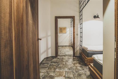 a hallway with a bed and a door to a bedroom at Penzion Šatlava in Nové Město nad Metují