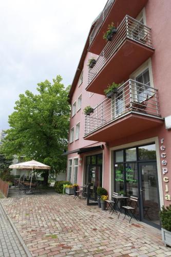 a pink building with a patio in front of it at Willa Park Międzyzdroje in Międzyzdroje