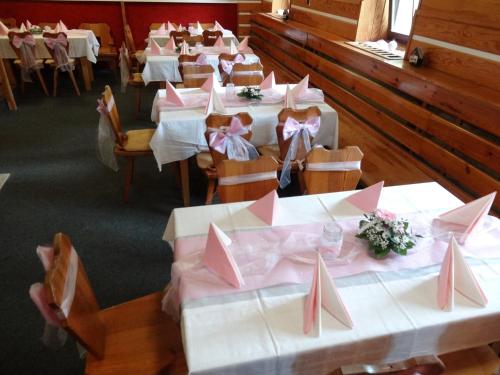 a row of tables with pink napkins on them at Horská chata Hubert in Bedřichov