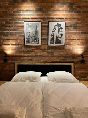 - une chambre avec 2 lits et un mur en briques dans l'établissement Donau Apartment Vienna, à Vienne