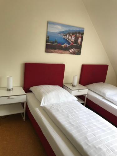 two beds in a room with two night stands at Hotel Garni Elisabeth in Göppingen