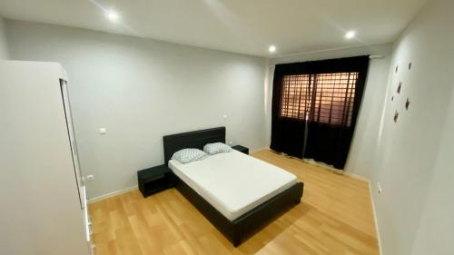 una camera con un letto in una stanza con una finestra di T1 Família Luz a Mindelo