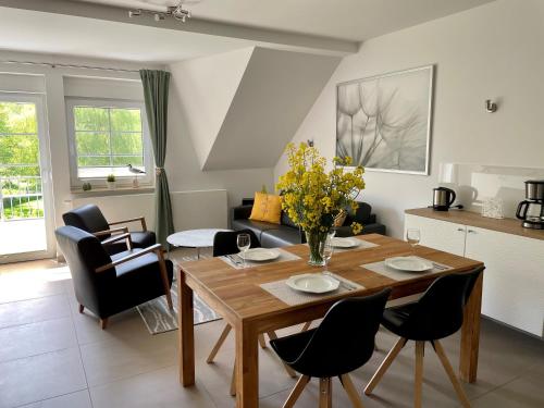 a kitchen and living room with a wooden table and chairs at Appartementanlage Lancken-Granitz in Lancken-Granitz
