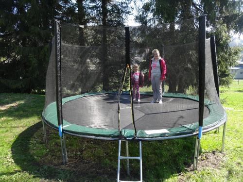 a woman and a child standing on a trampoline at Horská chata Hubert in Bedřichov