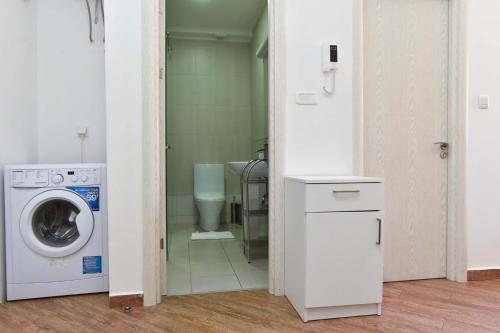 a bathroom with a washing machine and a toilet at Victoria Center Apartments in Budva