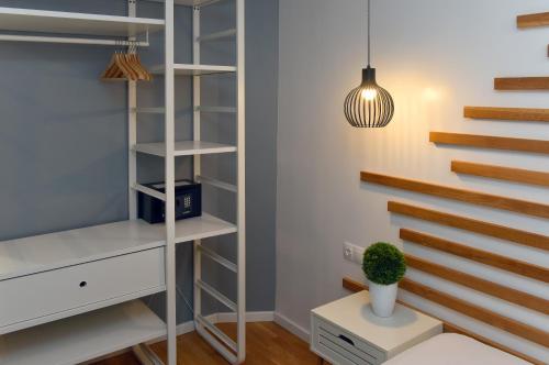 a walk in closet with white shelves and a potted plant at Walk Inn Váci 78 in Budapest