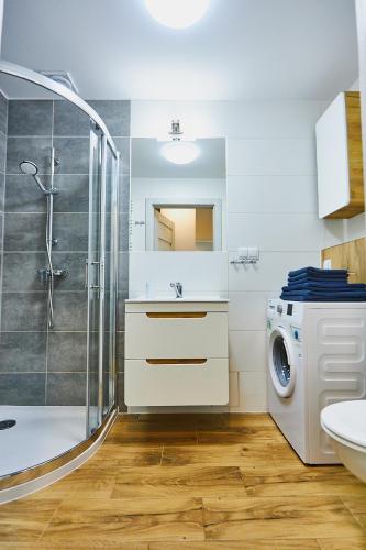 a bathroom with a washing machine and a washer at Apartament Cesarski in Świnoujście