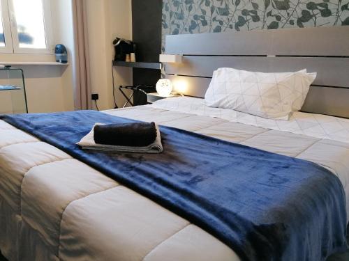 a large white bed with a blue blanket on it at B&B IL SOGNO in Turin