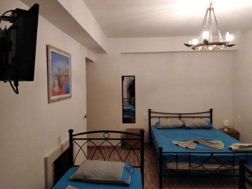 1 dormitorio con 2 camas y lámpara de araña en Magic Ionian Apartments & Rooms, en Himare