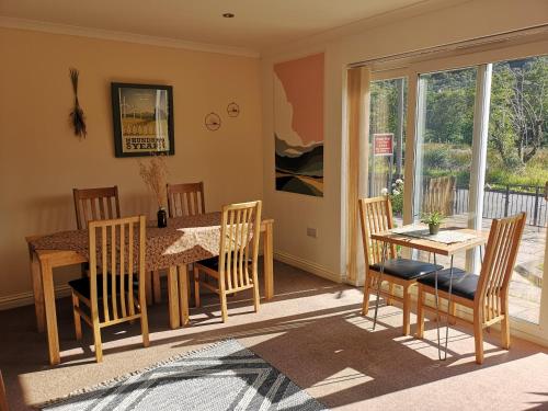 a dining room with a wooden table and chairs at Forest View Guesthouse, Kinlochleven WHW in Kinlochmore