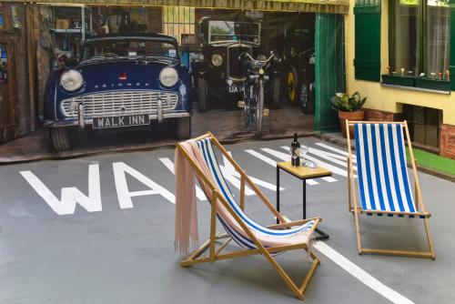 two chairs sitting in a parking lot next to a car at Walk Inn Váci 78 in Budapest