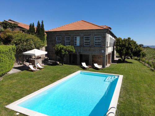 a swimming pool in the yard of a house at Quinta da Portela - Casa Visconde Arneiros in Lamego