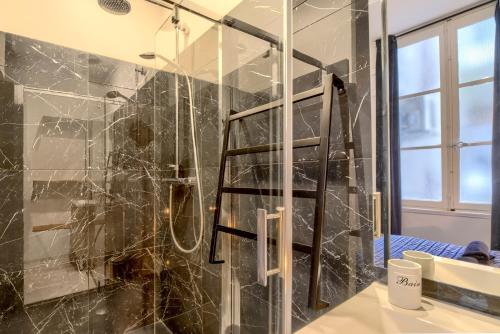 La salle de bains est pourvue d'une douche et d'une paroi en verre. dans l'établissement LE FEEL GOOD - En plein cœur de Bordeaux, à Bordeaux