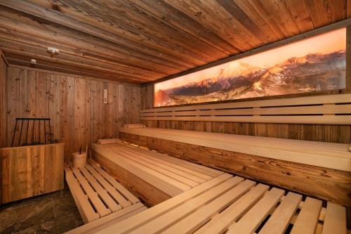 an empty sauna with wooden benches and a painting at dasKAISER - Dein Gartenhotel in Tirol in Ebbs