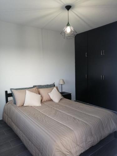 un grande letto con due cuscini sopra in una camera da letto di Ariadne apartment a Paralimni