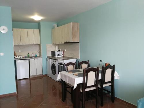 a kitchen with a table and chairs and a stove at Апартамент за гости Соня Guest Apartment Sonya in Nesebar
