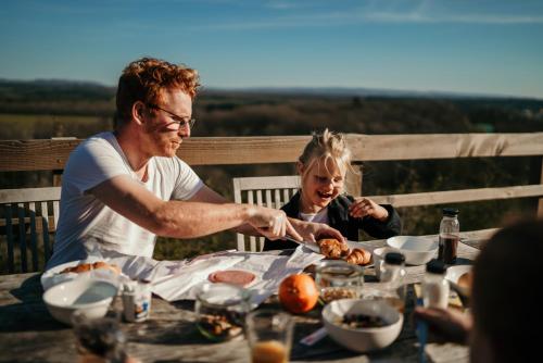 a man and a little girl sitting at a table eating food at Green Fields - Durbuy in Durbuy